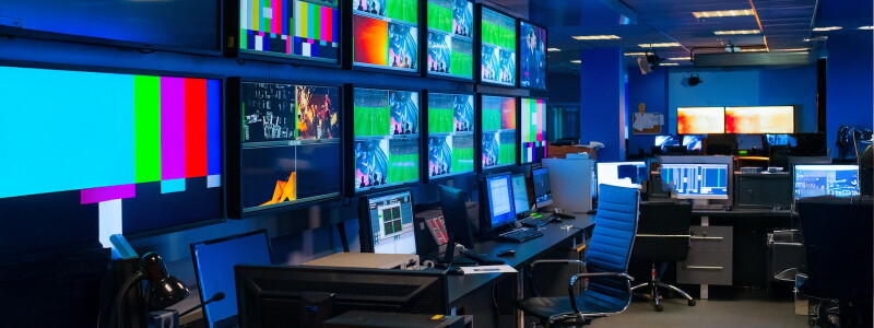 The control room for a sports game broadcast, full of screens and computers.