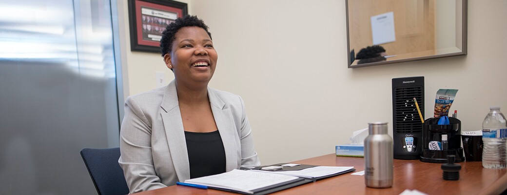 Professional Chico State student wearing a blazer and smiling in her office
