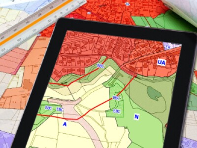 Maps and a tablet screen showing urban and rural landscapes