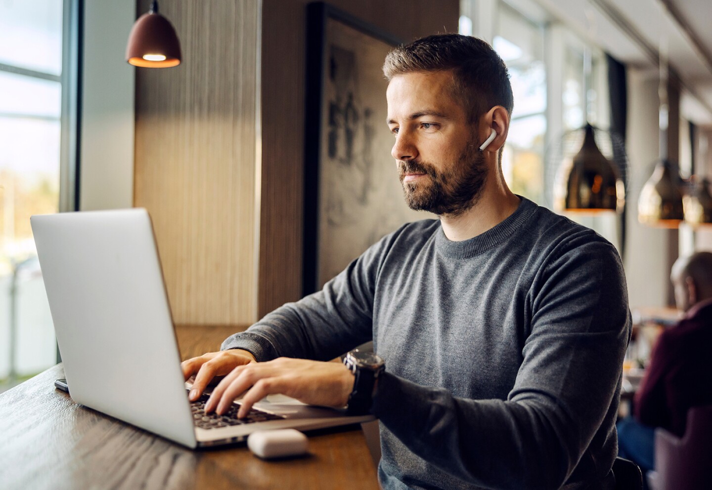 Student working on his laptop in a cafe