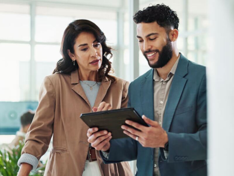 Man and woman in business attire looking at tablet