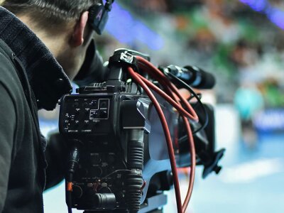 TV camera and cameraman during handball match.