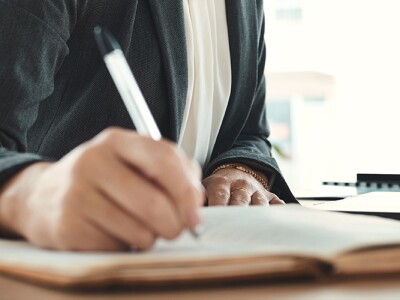 Close up a a woman writing in a notebook