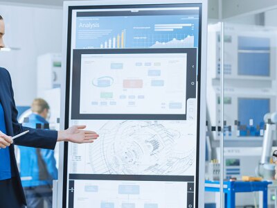 Female Engineer Uses Interactive Whiteboard, Makes Report to a Group of Engineers