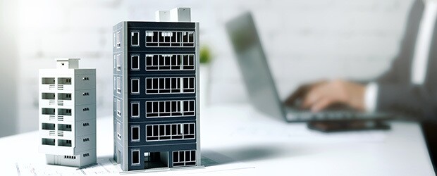 commercial vs. residential real estate, building models, man working