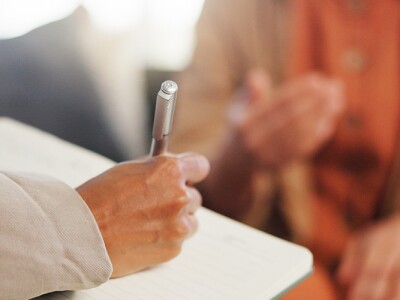 Counselor writing notes for client