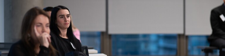 Two students listening to a speaker in a classroom