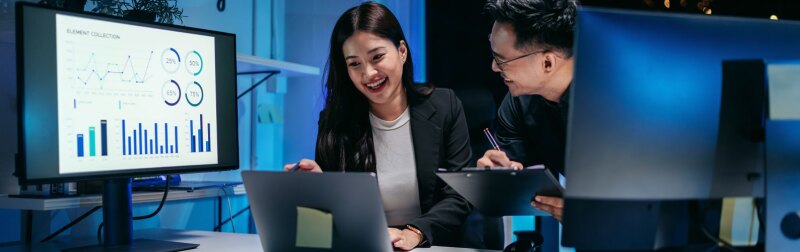 Business professionals collaborating on market analysis and AI driven data insights during focused late night office work.