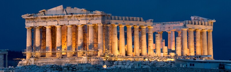 Image of the Parthenon lit up at night.