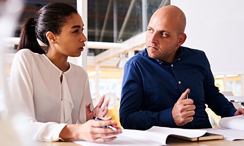 Two-Employees-Discuss-Workplace-Conflict