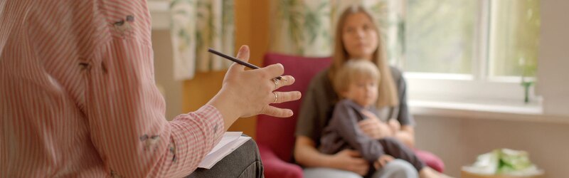 A counselor talking to a parent and child.