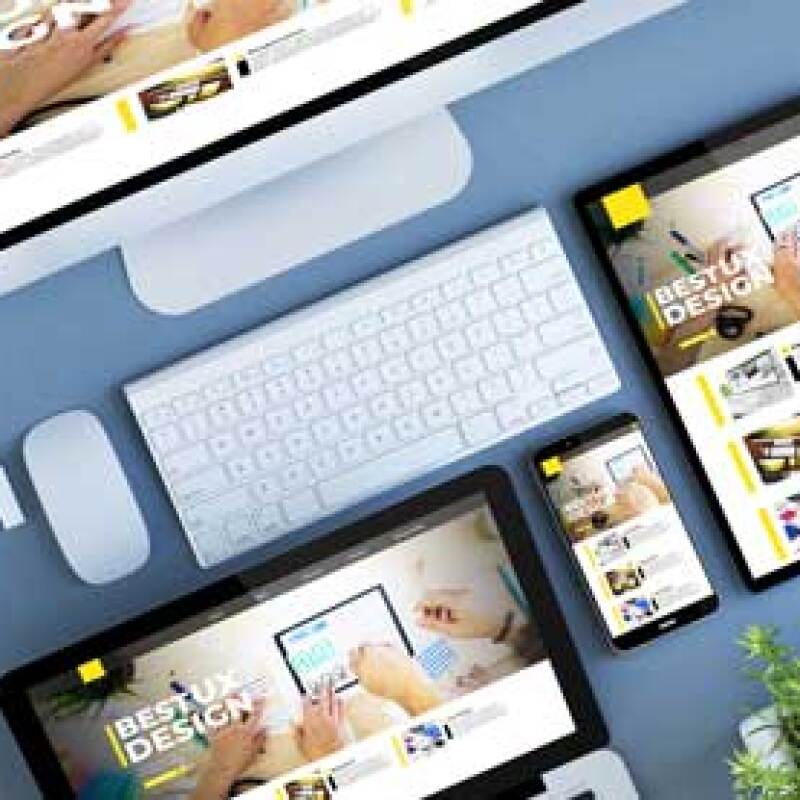 A UX Design product display sits on a table showing the same page on a desktop, tablet, phone and laptop.