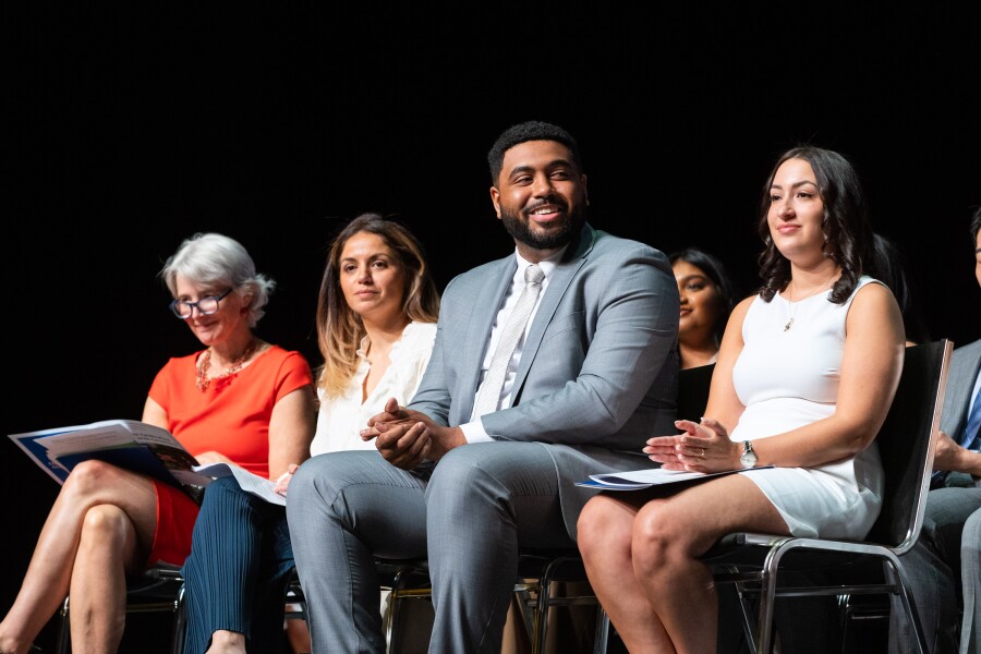 people in professional attire on stage seated