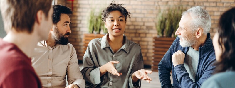 Clients listen to a social worker during a group session