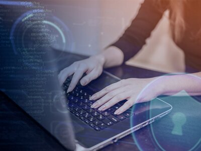 Person typing on laptop displaying cybersecurity icons