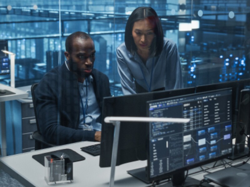 A male and female analysts review data.