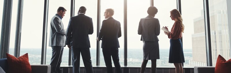 Business people, discussion and standing by window in boardroom with city view for career in real estate.