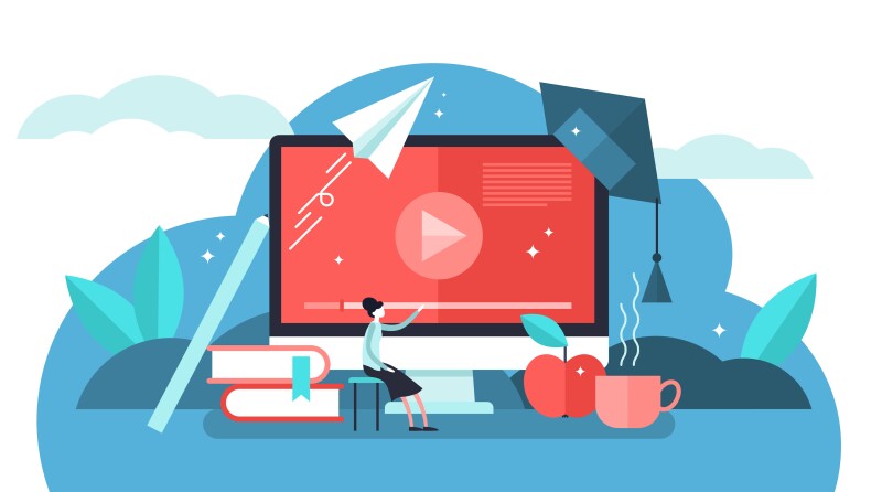 An instructor sitting in front of a computer screen displaying course materials