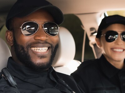 Smiling police officers in a patrol car.