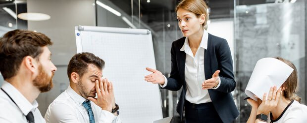Woman in meeting talking to frustrated colleagues
