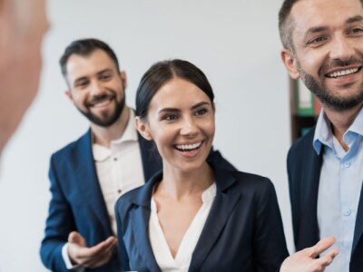 An Athletics Director and three employees review sports program schedule in office.