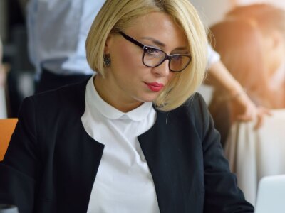 Concentrated businesswoman focused on laptop in office environment