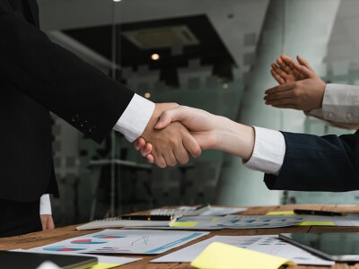 Two business professionals sealing a merger deal with a handshake