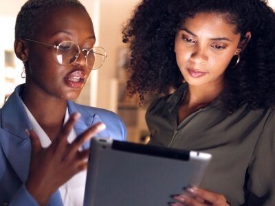 Black businesswoman in a meeting for corporate strategy and collaborating in an office with a colleague.