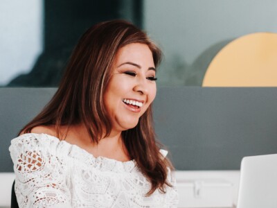 A woman with a laptop researching how much sports managers make.