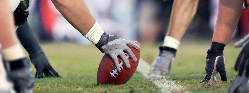 American football players lined up, ready to snap the ball.