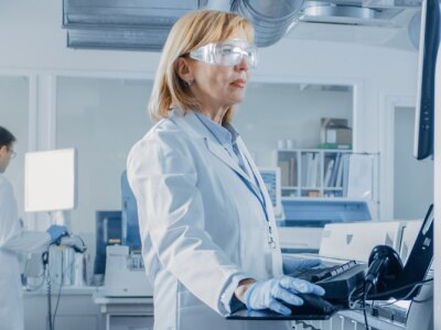 Female Scientists Programs Medical Equipment with Personal Computer.