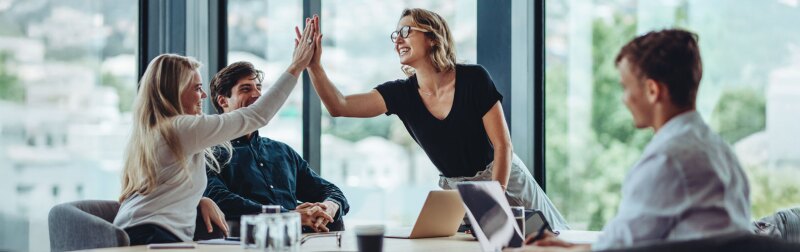 Group of business colleagues celebrating success with a high-five.