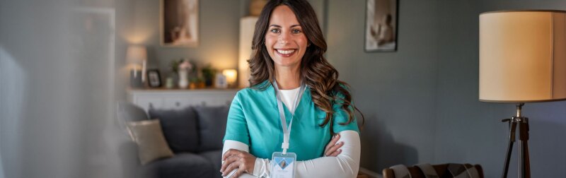 Smiling female nurse providing care in home environment.