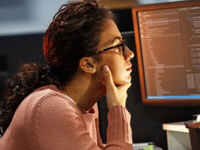 woman looking at computer screen full of data