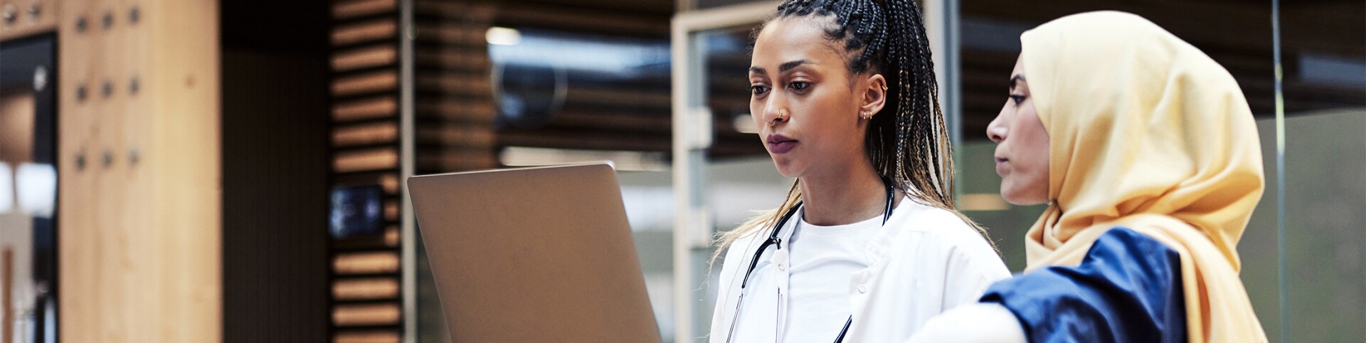 Female doctor and female nurse looking at laptop together