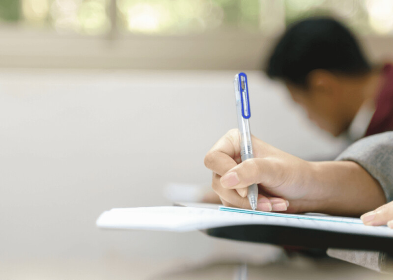 Hand with pen writing on a test sheet