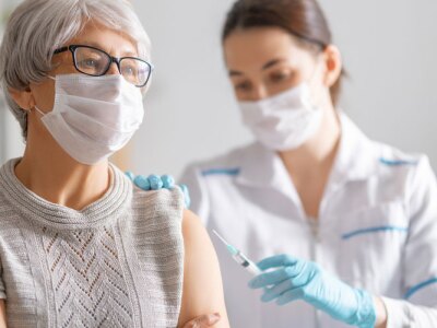 Doctor giving a senior woman a vaccination.