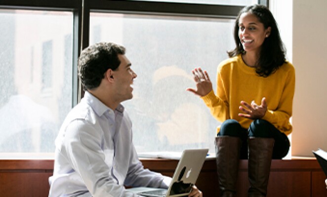 man with laptop in a conversation with a woman