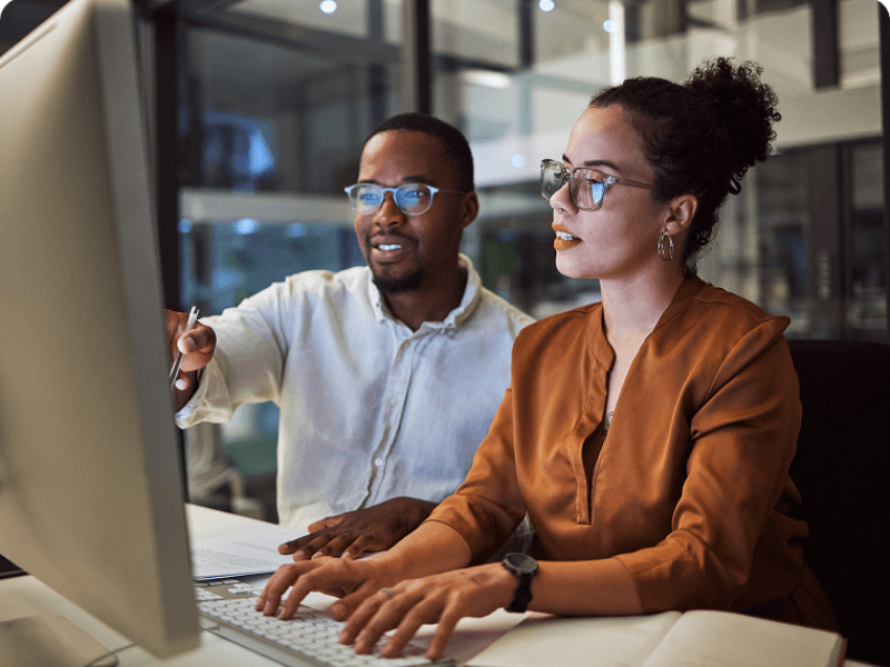 Man and woman collaborating at laptop screen