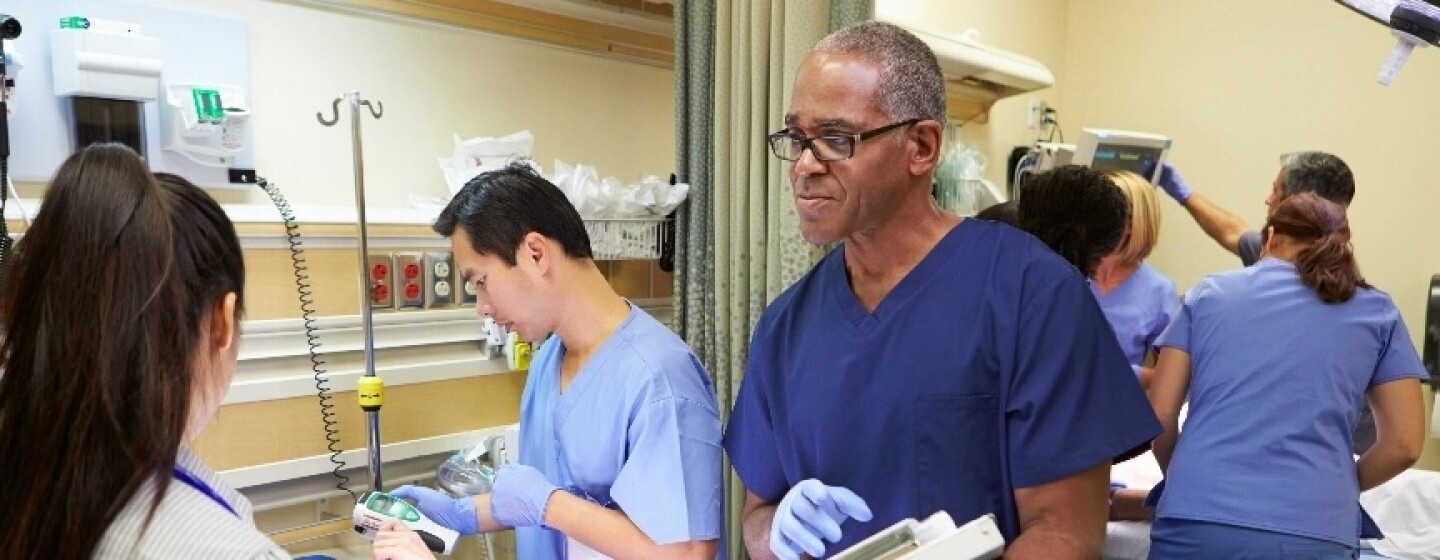 Nurses in scrubs working with various machines