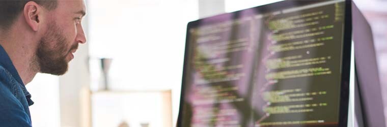 man on computer looking at code