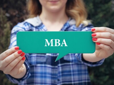 woman holding up an online mba program card