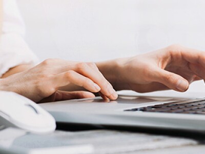 Female hands typing on computer keyboard searching for social work buzzwords