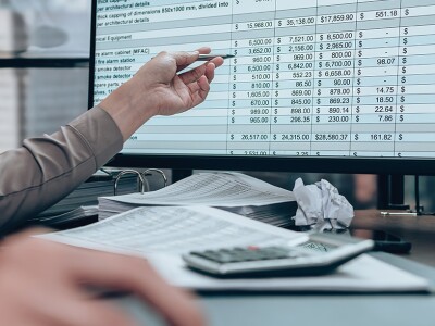Businessman working on desk and checking cost, balance, and profit reports