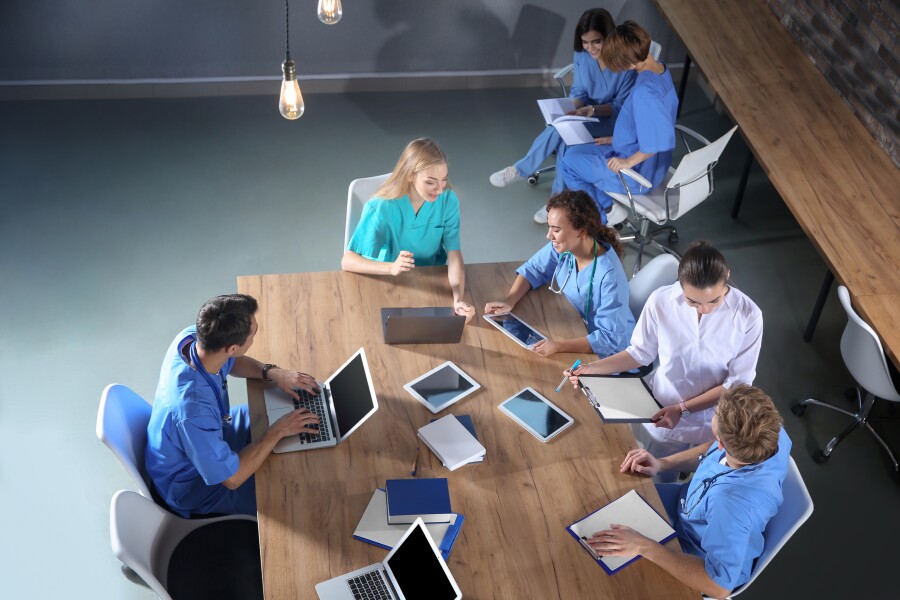 Group of medical students with gadgets in college, top view