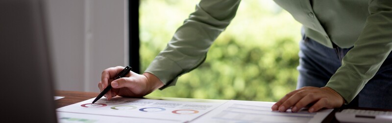 Female accountant reading documents and writing notes