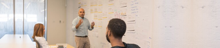 IMC students working through a product market strategy on a white board