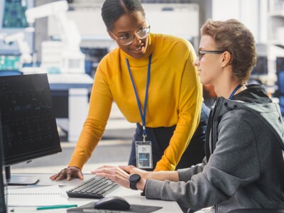 Manager Having a Conversation with Co-Worker, Collaborating on a Technology Project.
