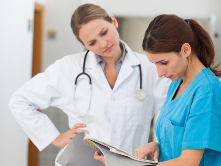 Doctor and nurse looking over report in medical setting