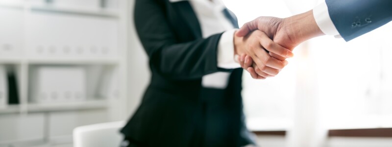 Close-up of two business executives shaking hands in an office
